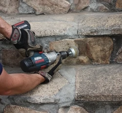 A drill-mounted wire brush can clean dirty masonry accurately and efficiently.