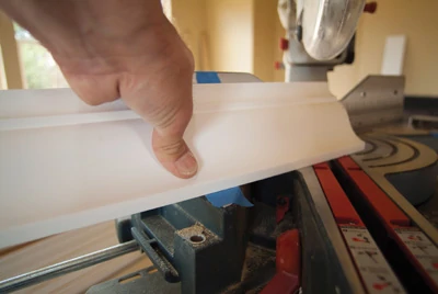 Since the crown goes on the saw upside-down, put the ceiling mark on the table and the wall mark on the fence. Begin a cope cut by making a 45-degree miter back toward the length of the board. 