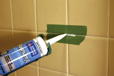 Waterproof caulk can be used to fill small cracks in tile grout.