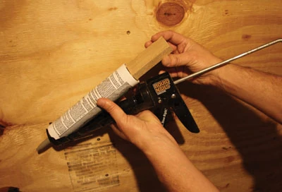 Squeeze out the last bit of caulk from your tube by using a wood block or dowel as a plunger extension.