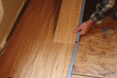 With vinyl planks, the adhesive strips on the ends are joined first.