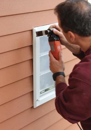 We used an oscillating multi-tool to carefully cut the siding to recess the door into the wall, giving it a more finished appearance and eliminating air gaps. 