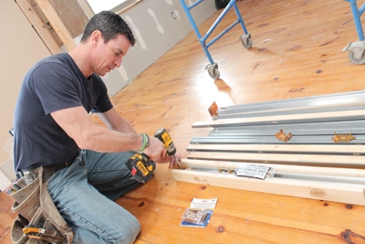 For a double door, assemble the tracks using the included mending hardware. Make sure to get them flush and keep them straight. Snap a chalk line if necessary. I lined them up with a floorboard as a guide.