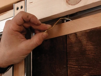 Install the stops so the doors kiss when they close. Leave your power tools out of this one, though. Just snug them up with a screwdriver. Use the world’s smallest wrench to adjust the doors into plumb.