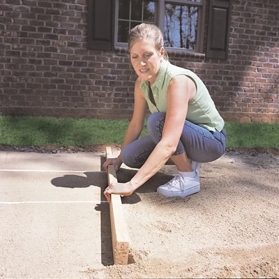 Cover the gravel bed with concrete sand (course, jagged sand) and use a board across the top of the pipe to screed the sand level. 