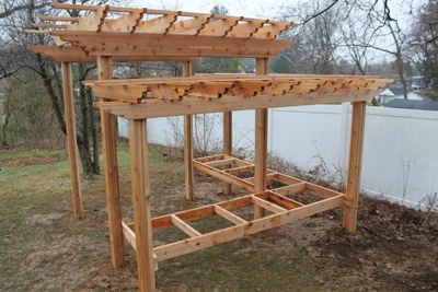 This two-level pergola includes framing for a bench or serving table. 