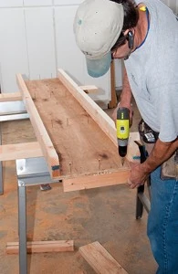 Turn the table over and use drywall screws to attach the wing board support blocks from the underside of the table. 