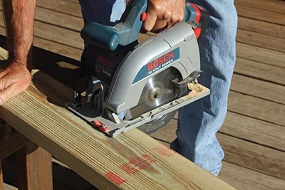 A cordless circular saw makes quick work of cutting deck boards to length. 