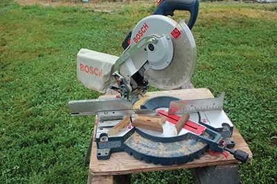 Trim boards are first routed to create a rounded edge, then cut to 45 degree angles to fit around awing posts. The Bosch cordless miter saw makes the on-site work easy. 
