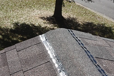 We installed shingles all the way to the ridge line then trimmed the excess at the top. 