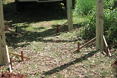 Brace the posts from each side to hold them in position while you pour the concrete footings.
