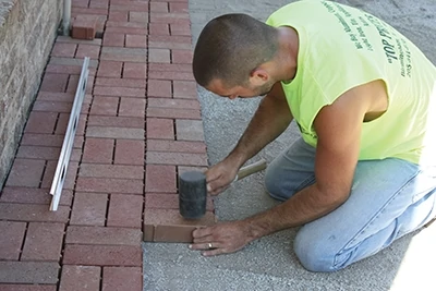 Use a rubber mallet to set the pavers firmly all joints with paver sand to lock them in place. 