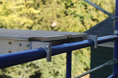 The walk boards hook over the tubular frames with a firm connection that prevents slippage underfoot. 