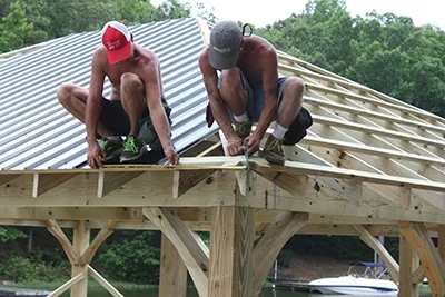 Work toward the sides of the roof deck, cutting panels to fit as necessary.
