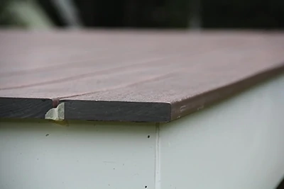 To guide our ¾” decking overhang, we temporarily face-nail a ¾” board around the rim to use as a gauge. Once installation is complete, remove the board and paint/stain the rim. 