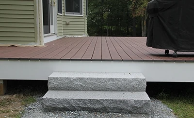 Granite steps provide access to the finished deck. 