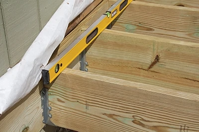 Most decks begin with a ledger board connected to the house rim joist. 
