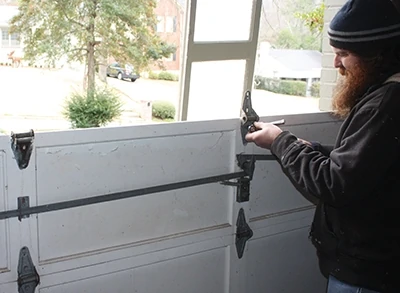 To disassemble a garage door, unscrew the individual panels one at a time, working from the top downward. 