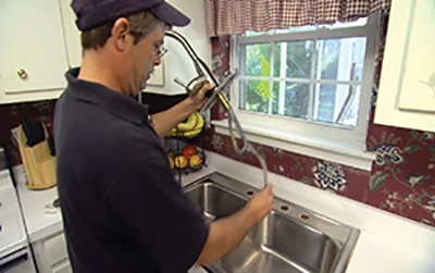 Feed the fixture through the mounting holes of the sink. 