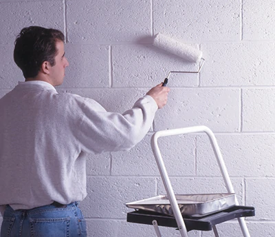 If applying a masonry waterproofer with a roller, back-brush the coating to work it into the pores of the block. A minimum of two coats is required. 
