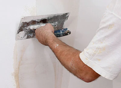 Minor wall damage can be repaired using a trowel or putty knife with lightweight joint compound or vinyl spackling. Feather the edges of the patch to blend with the wall surface. 
