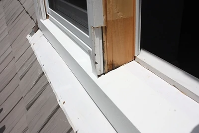 The installer shapes the aluminum on a metal-bending brake then cuts it to fit snuggly around the window sill. 