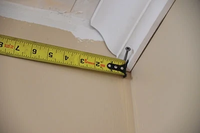 I like to take a 'real life' measurement. It's a helpful idiot-proof practice for me. I fasten a test piece in the corner and measure from it to the opposite corner. Tip for working alone: Pinch the hook of the tape measure against the molding with a screw. 
