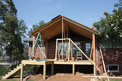 The roof is erected over a deck that will be screened as an outdoor living area. 