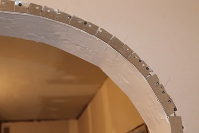 During the drywall phase, multiple sequential cuts were made in the corner bead so it would bend around the curve of the archway.