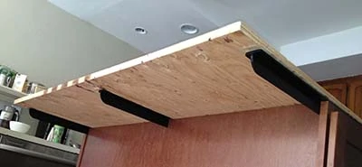 Counterbalance supports are shown under the plywood. Overhangs greater than 6" need such additional support. This style support, as opposed to corbels, is less likely to bang knees or get in the way of stools. 