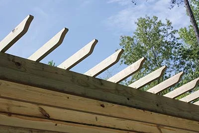 On top of the rafters, a layer of 2x4 purlins are installed at 90 degrees to the rafters and fastened in the same manner. 