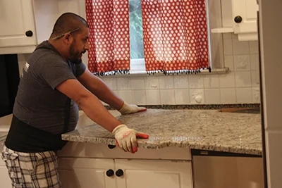Carefully set the new granite countertop section in place on the cabinet base. 