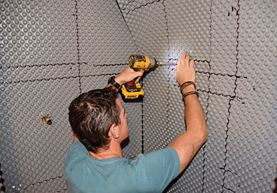 The DPM creates an air gap that facilitates drainage and ventilation of any water vapor that gets behind the shower panels. Any time you install a sheet product, it's important to get the membrane taught and flat, otherwise lumps and bumps and ripples will chase you around. Washer-head screws work better than drywall screws here.