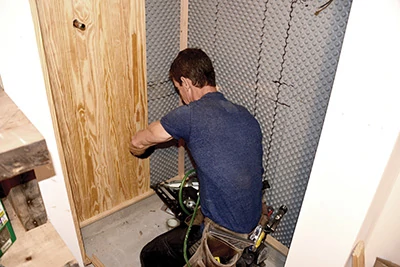 After coating their backs with Spar Urethane, the tongue-and-grove cladding is installed as the shower surround. 