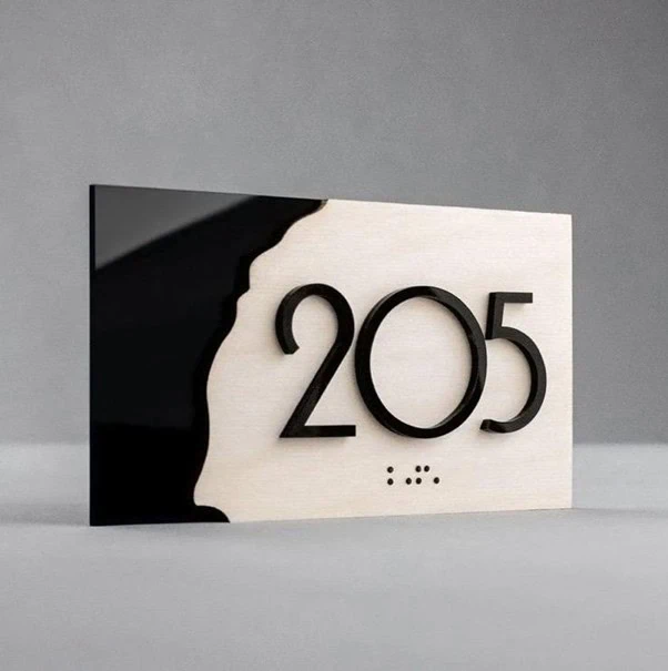 Minimalist wall-mounted room sign with contrasting materials and raised typography