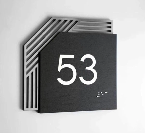 Modern layered room sign with raised numerals and geometric metal backing”