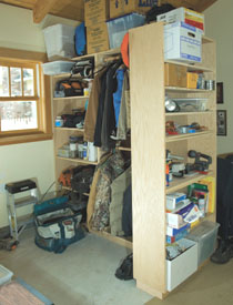 Three cabinets configured in a garage: Two 16” cabinets side by side with one 12” unit attached on the end. One of the cabinets has been outfitted with closet rods for hanging clothes.