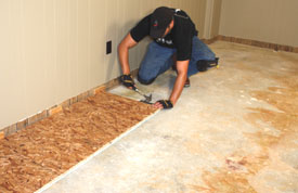 Join the tongue-and-groove subfloor panels with a hammer and block.
