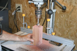 Shows a Forstner bit in action as it cuts a block of wood