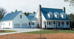 A house and a garage that both have metal roofs